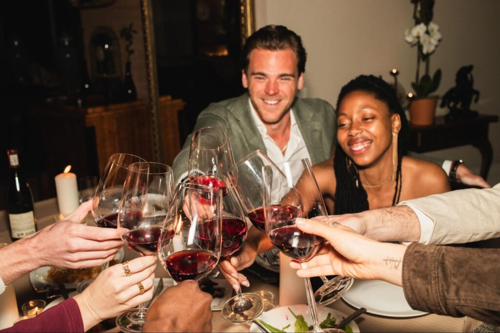 A group of diners toasting with glasses of wine